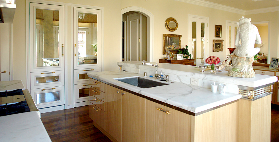 The metal embellished hood shown here in this open spaced kitchen sets the stage for this elegant apartment.