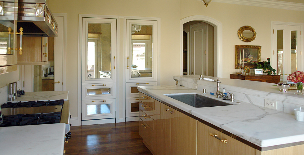 The metal embellished hood shown here in this open spaced kitchen sets the stage for this elegant apartment.