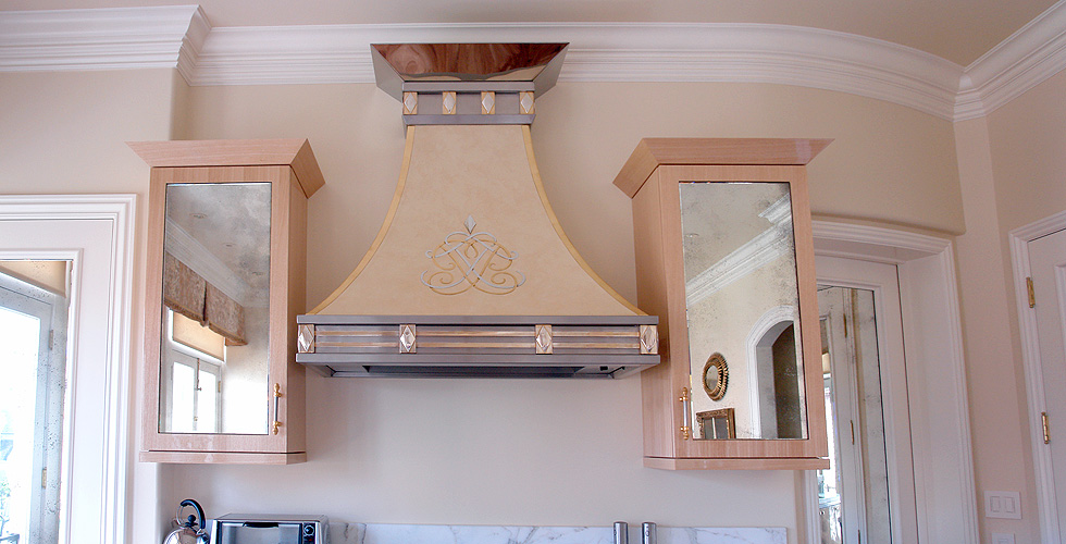 Kitchen hood topped with mirrored stainless steel, faux-painted and softened with glossy taywood cabinetry surrounding